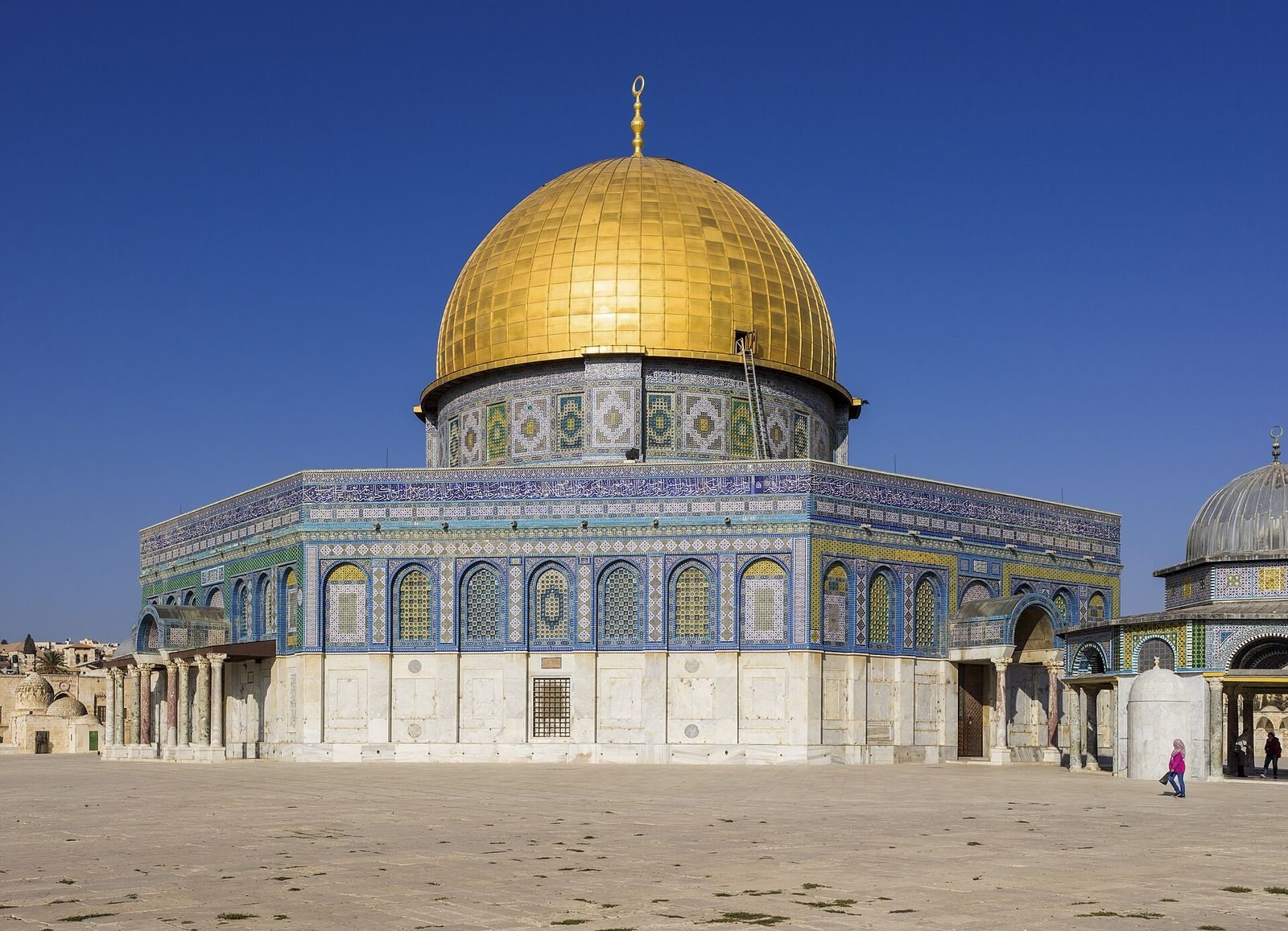 Vision d'artiste d'une caravane de chameaux sous un ciel étoilé approchant le Bagdad de l'âge d'or, la Maison de la Sagesse flamboyant de lumière