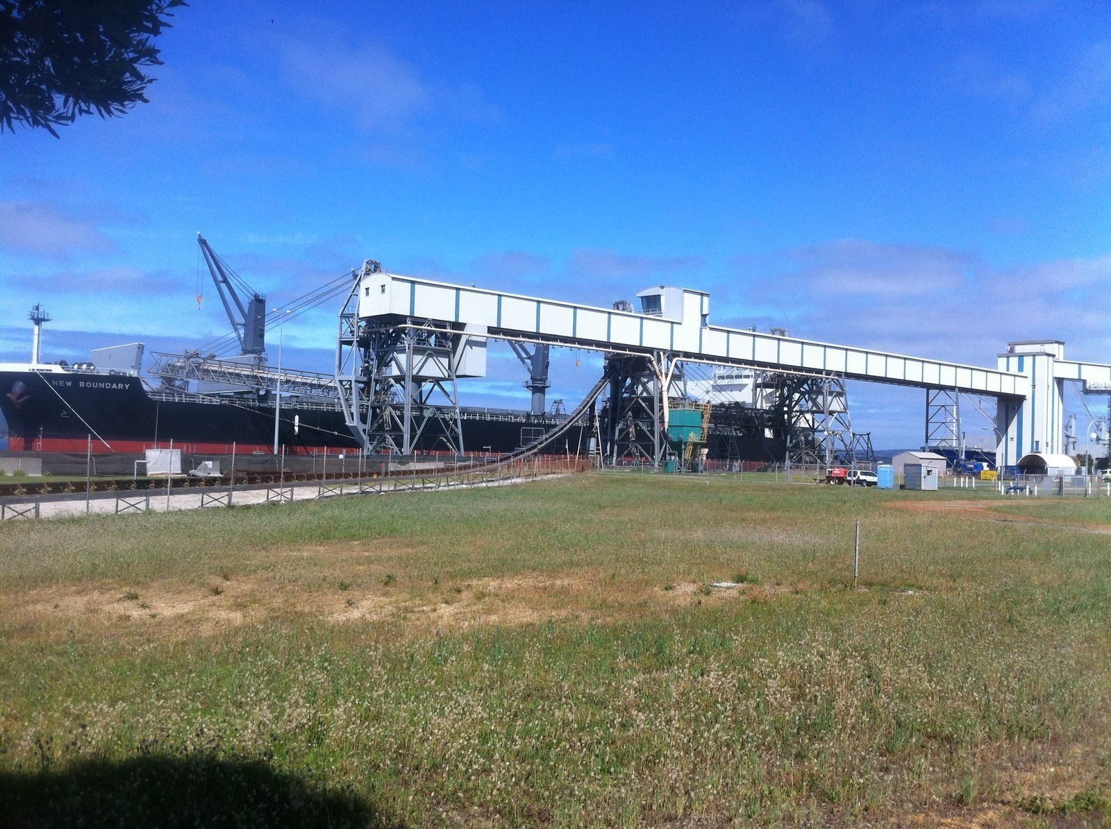 A bulk carrier being loaded with grain at a port terminal