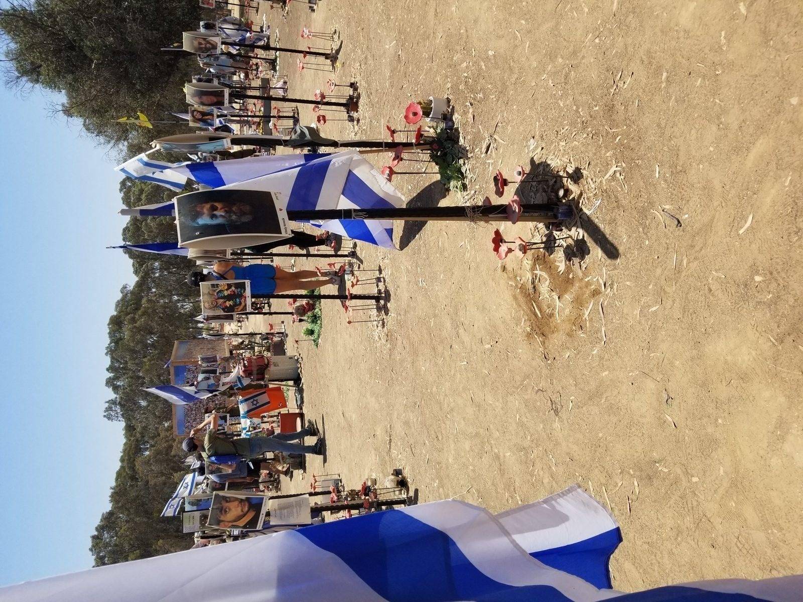 Memorial site at Re'im in southern Israel, marking the October 7, 2023 attacks, with quiet flags and stones under a desert sky